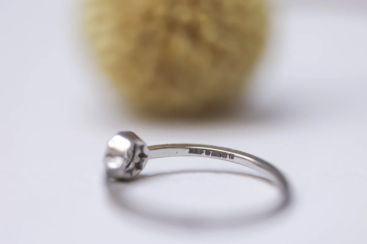 Silver ring with a blurred yellow object in the background