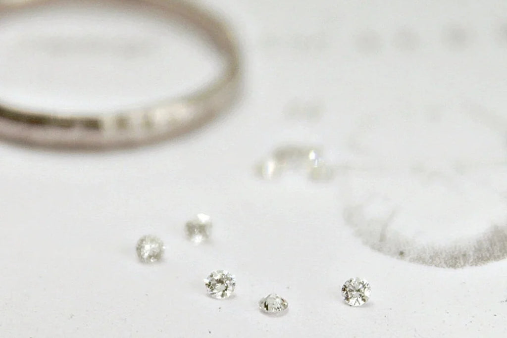 Close-up of silver jewelry including rings and earrings on a light background