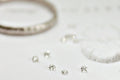 Close-up of silver jewelry including rings and earrings on a light background