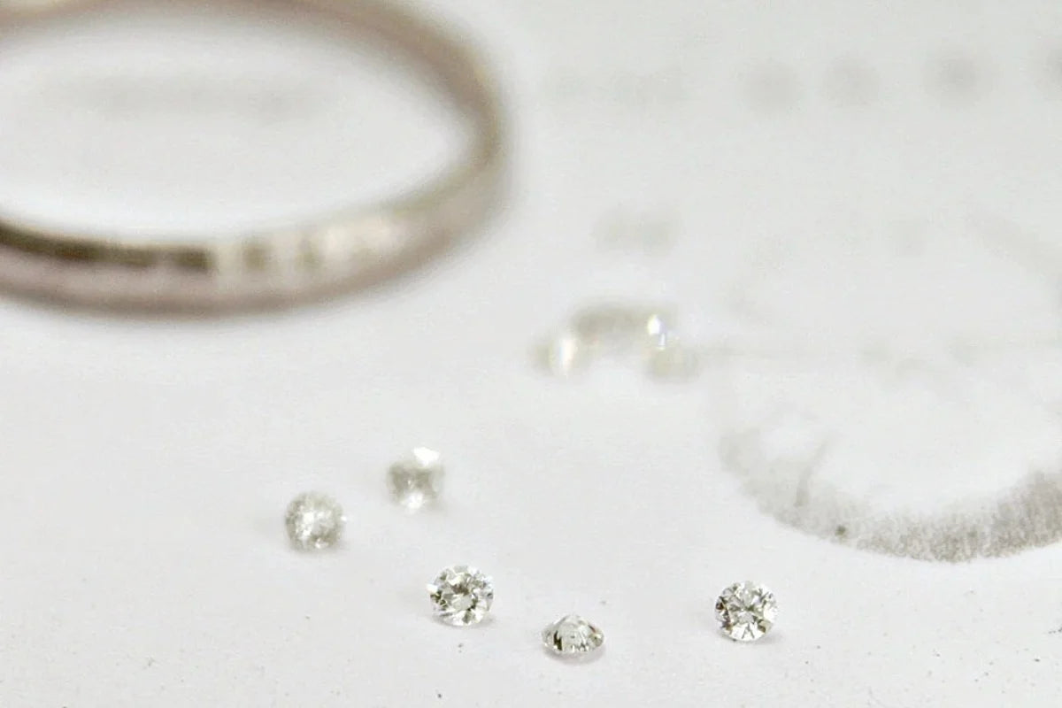 Close-up of silver jewelry including rings and earrings on a light background