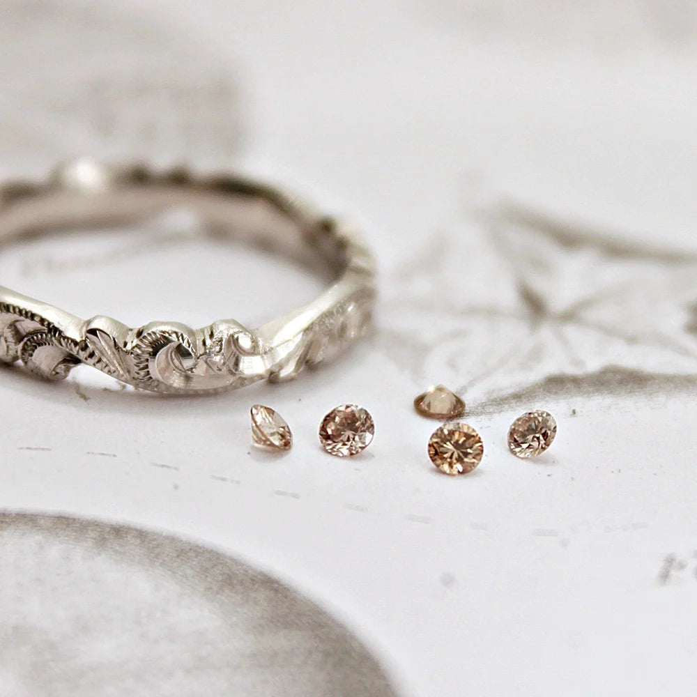 Silver ring and diamond rings on a light wooden surface
