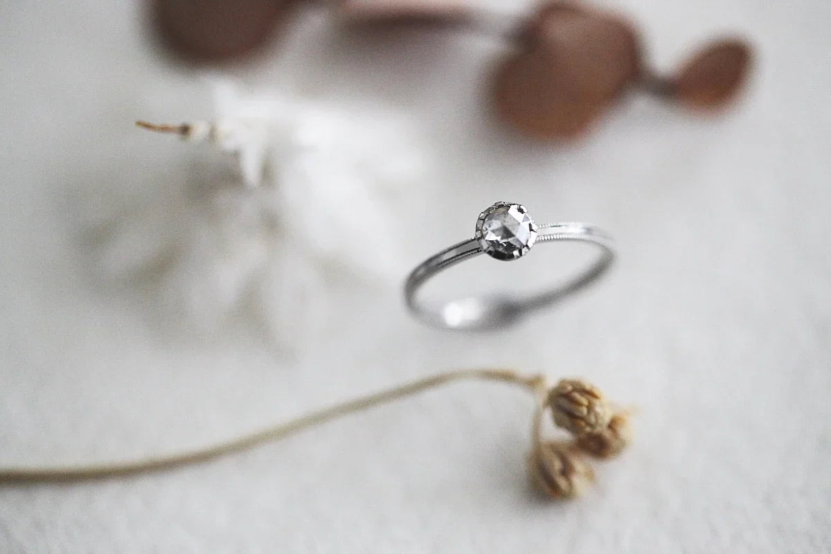 Silver ring with a diamond on a light background