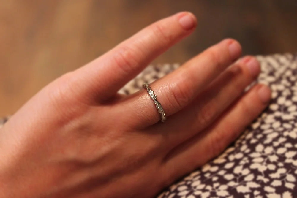 Platinum floral carved wedding ring worn on hand
