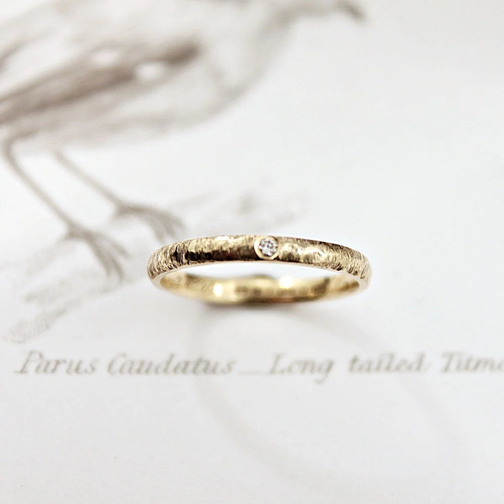 Gold ring with a diamond on a light background