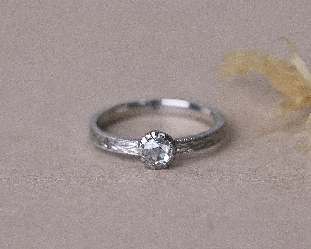 Traditional cut-down setting holding a rose-cut diamond in platinum