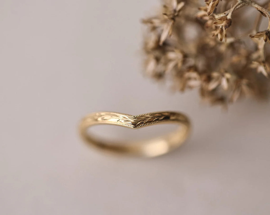 Soft focus view of handmade yellow gold olive leaf wishbone ring