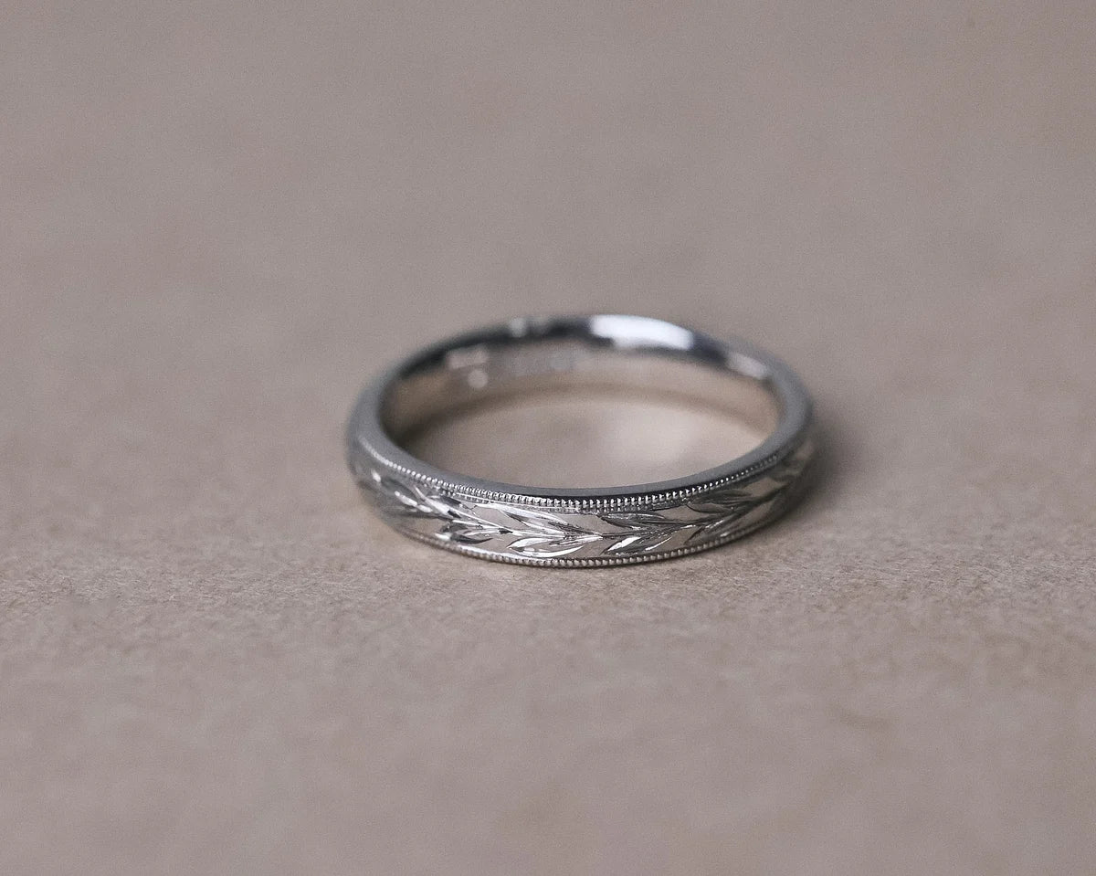 Front view of 3mm platinum wedding band with olive leaf engraving