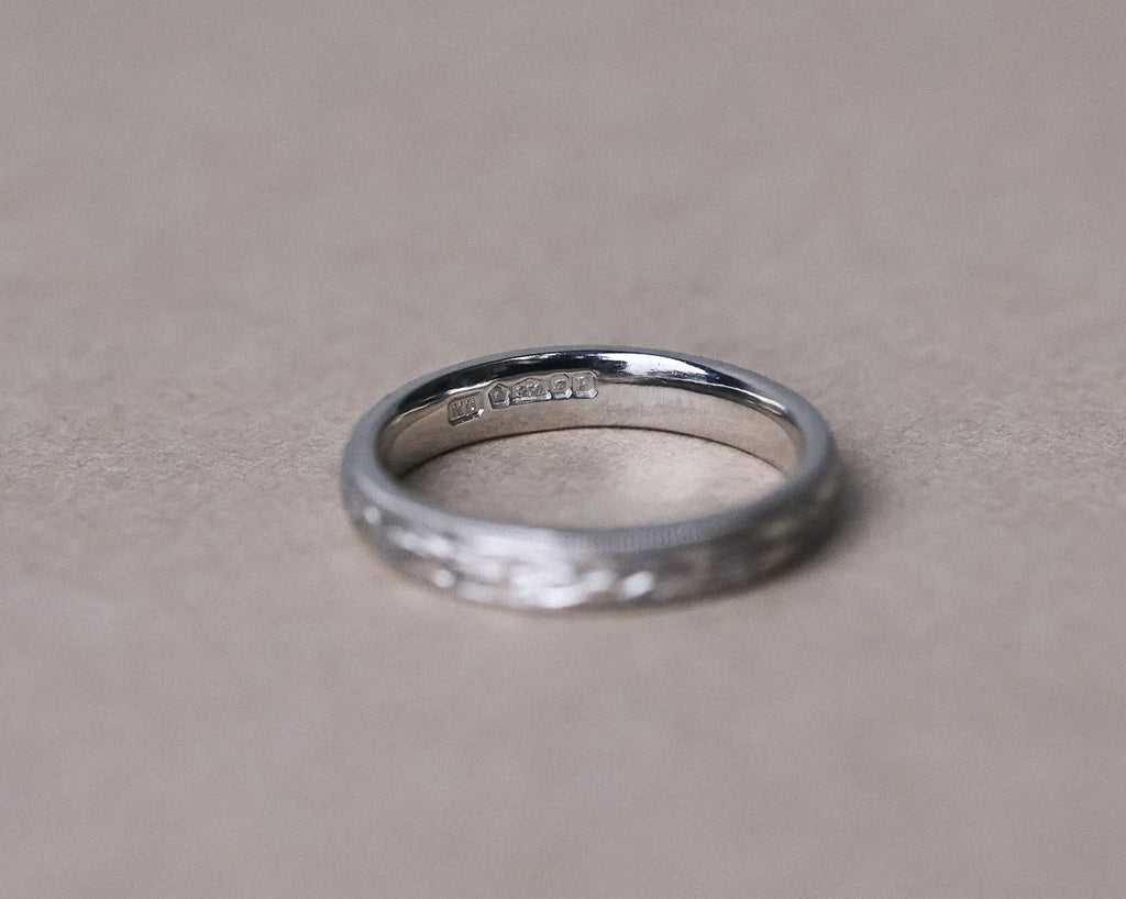 Minimal platinum wedding ring with hand engraved olive leaf motif