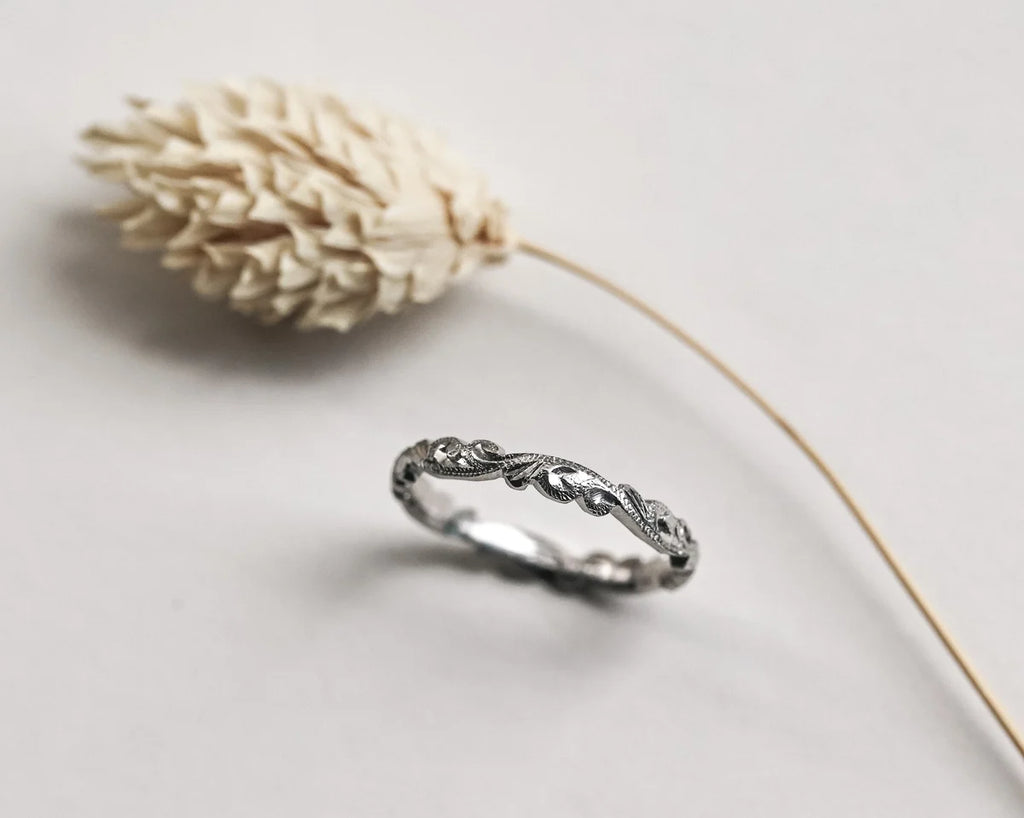 Angled view of platinum floral carved wedding ring with botanical styling