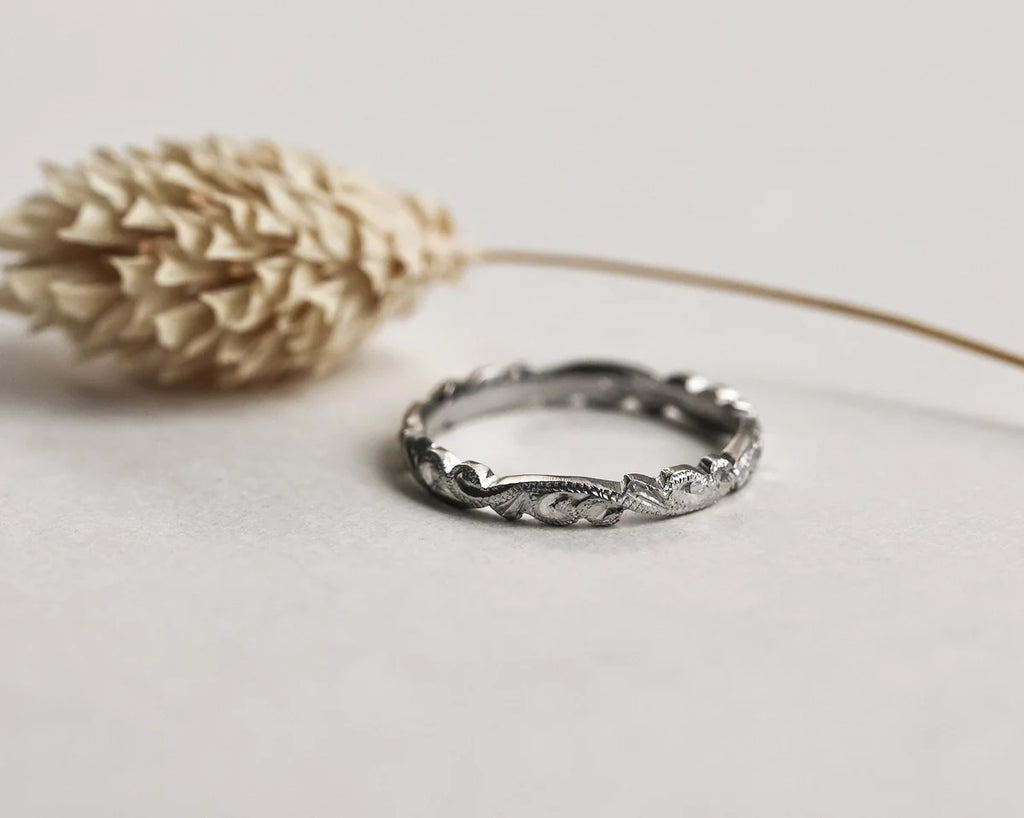 Close-up of hand carved floral detail on platinum wedding band