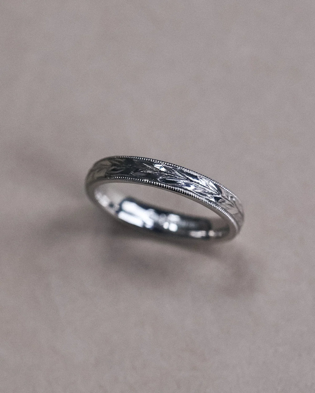 Side view of platinum olive leaf engraved ring with fine milled edge