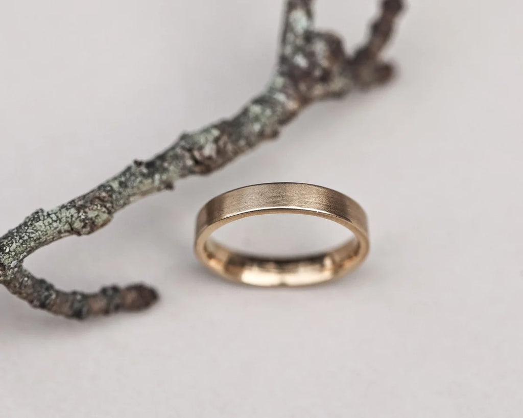 Gold ring on a branch with a white background