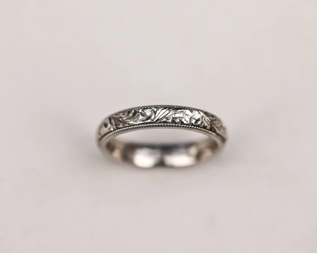 Close-up of handmade floral and milled edge wedding ring