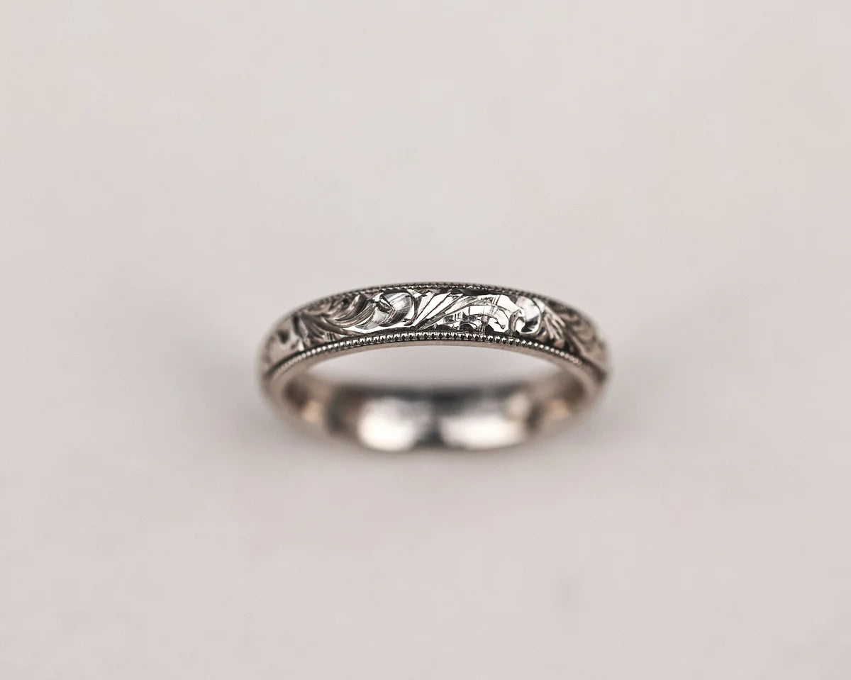 Close-up of handmade floral and milled edge wedding ring