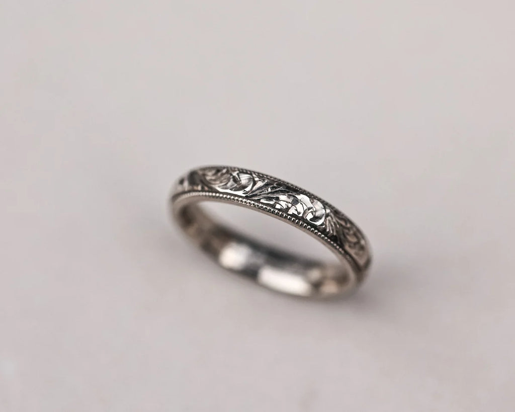 Angled profile of floral milled edge wedding ring in white gold
