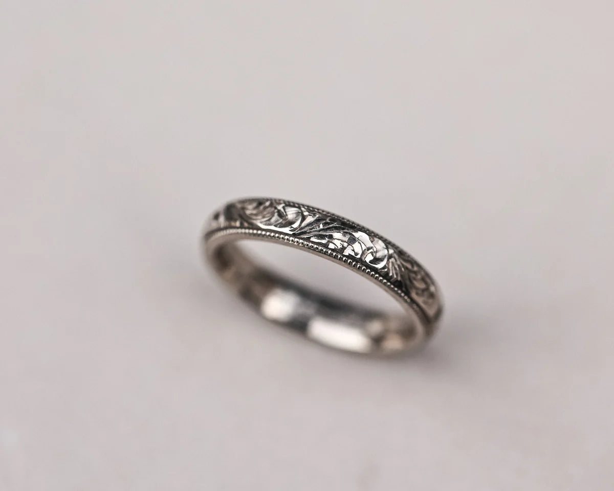 Angled profile of floral milled edge wedding ring in white gold