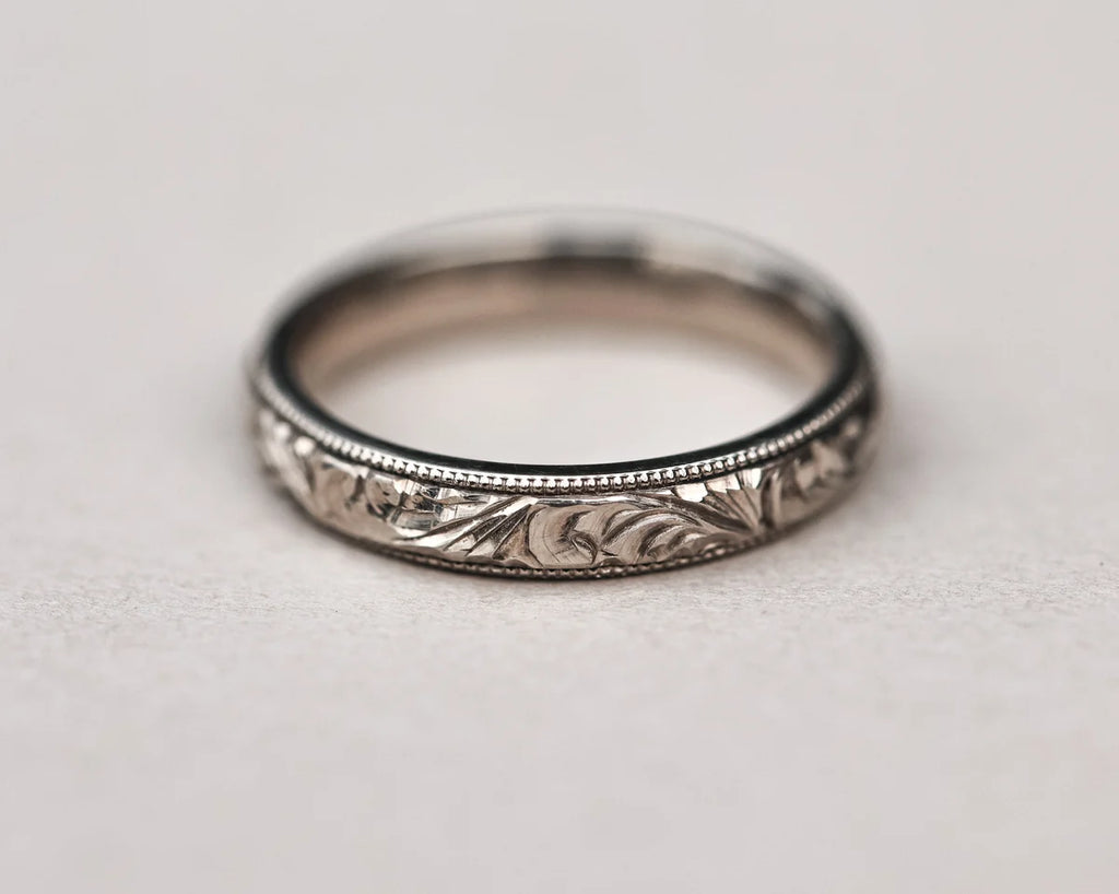 Detailed view of floral engraving and milled edge on white gold band
