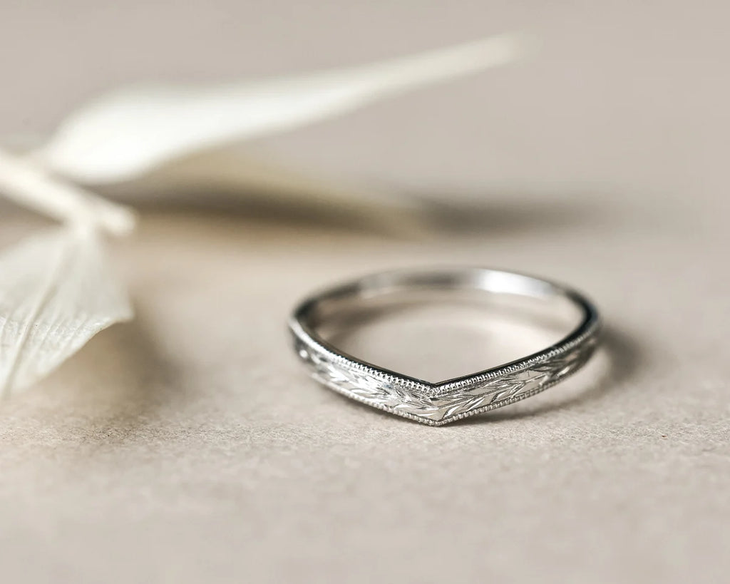 Detailed view of platinum wishbone ring with fine milled edge