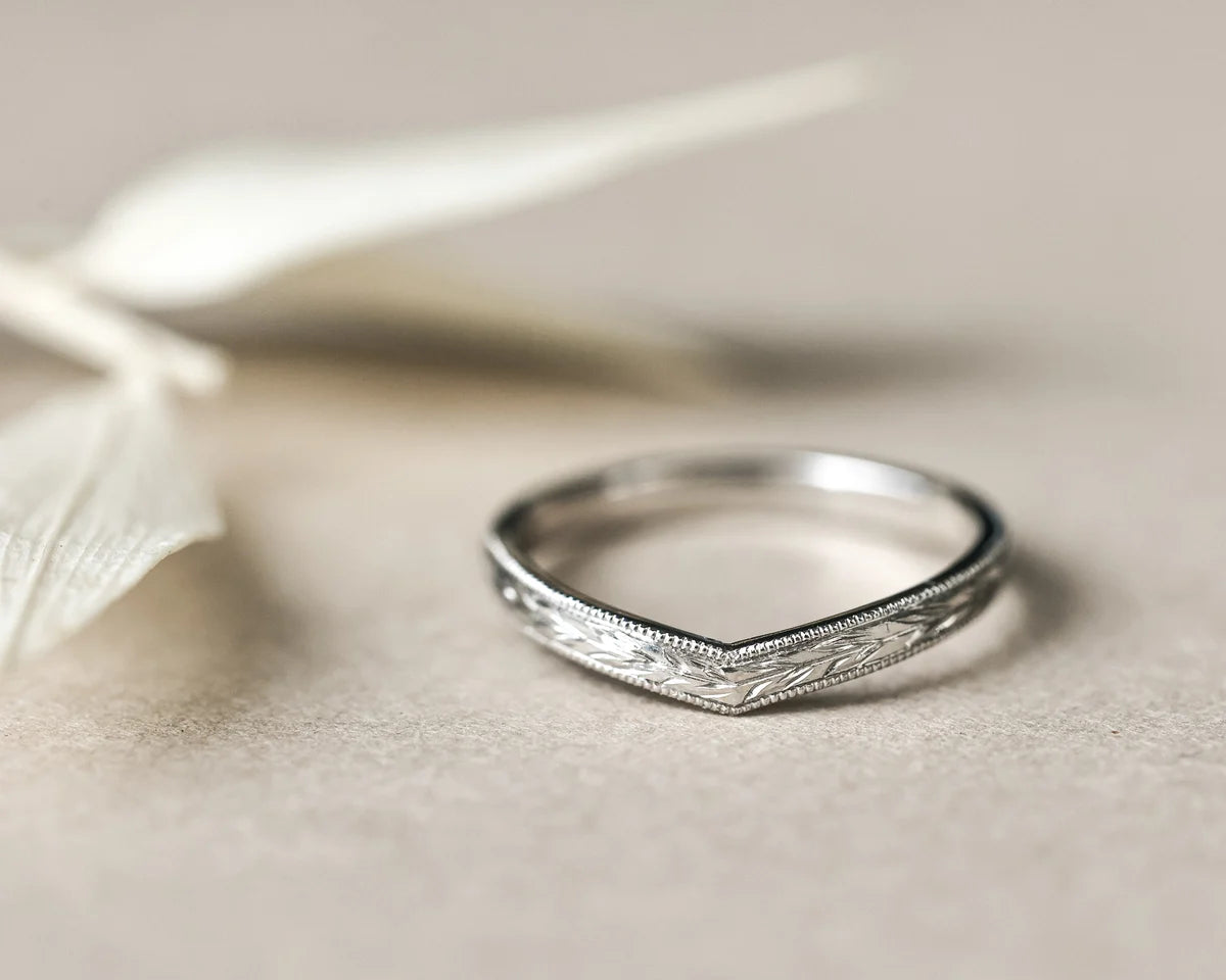 Detailed view of platinum wishbone ring with fine milled edge