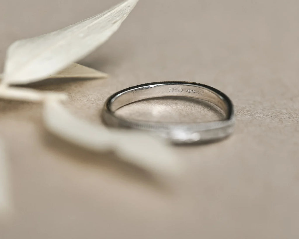 Side profile of platinum wishbone ring with olive leaf engraving