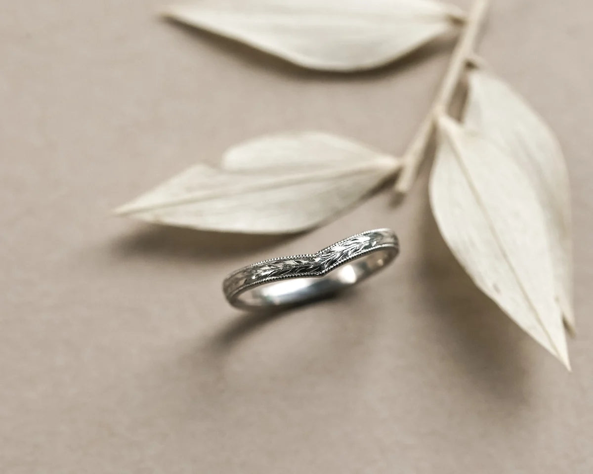 Side view of platinum olive leaf and milled edge wishbone ring