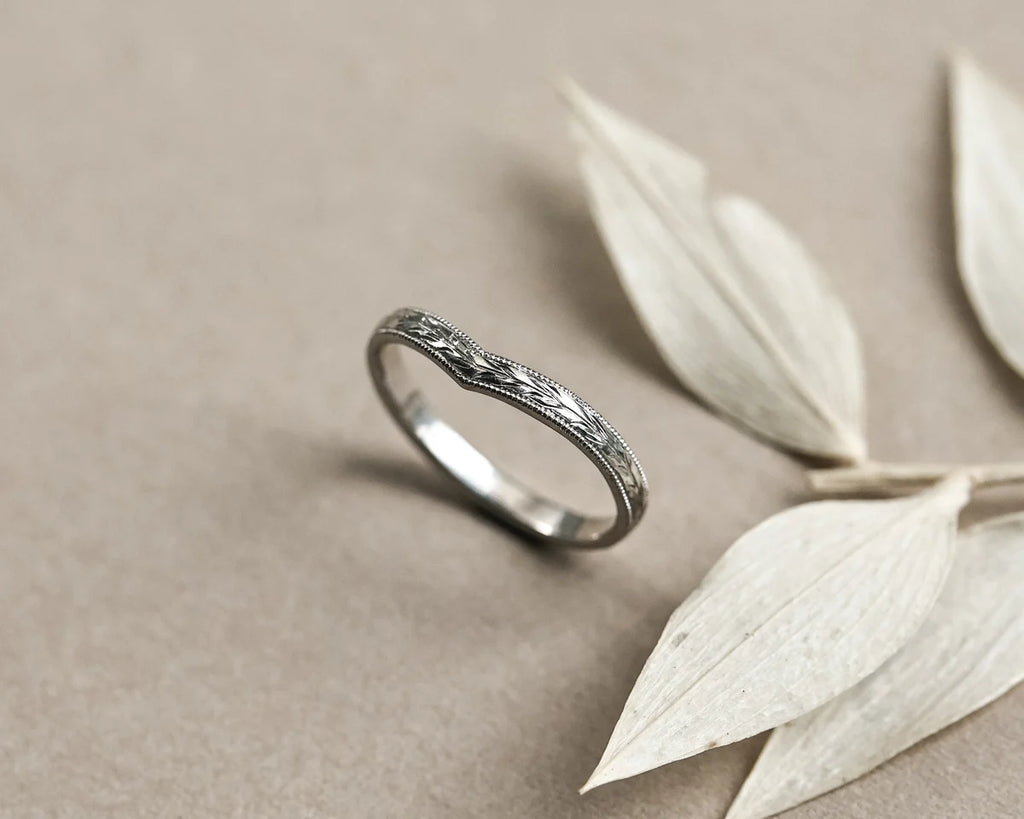 Angled view of handmade platinum olive leaf wishbone wedding band