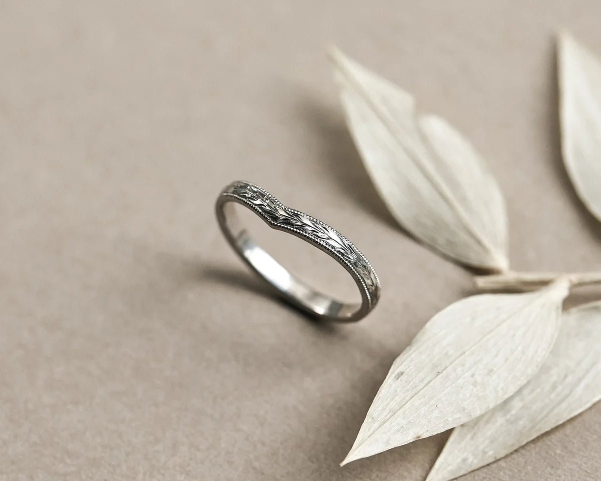 Angled view of handmade platinum olive leaf wishbone wedding band