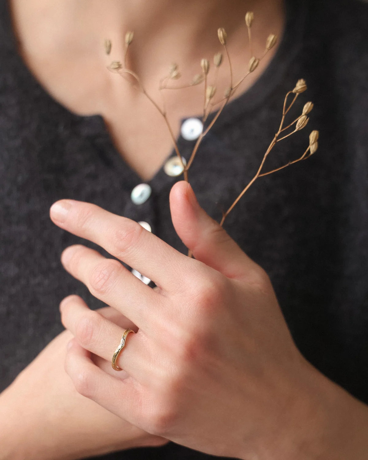  18ct yellow gold olive leaf wishbone ring worn with grey shirt
