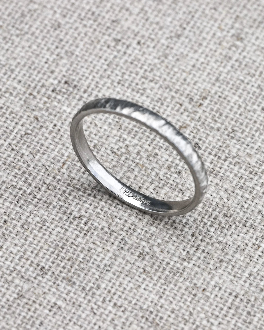 Silver ring on a textured gray fabric background