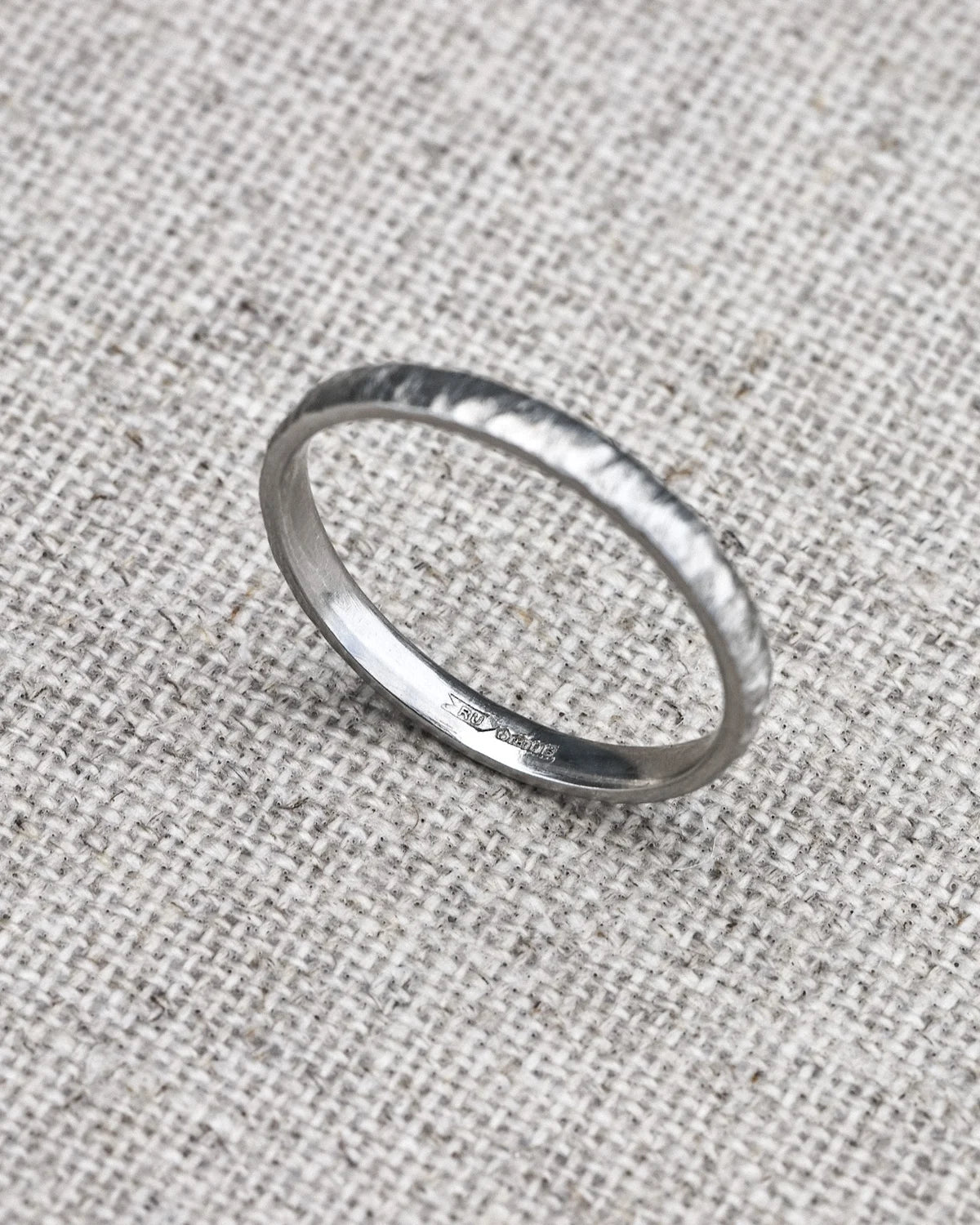 Silver ring on a textured gray fabric background