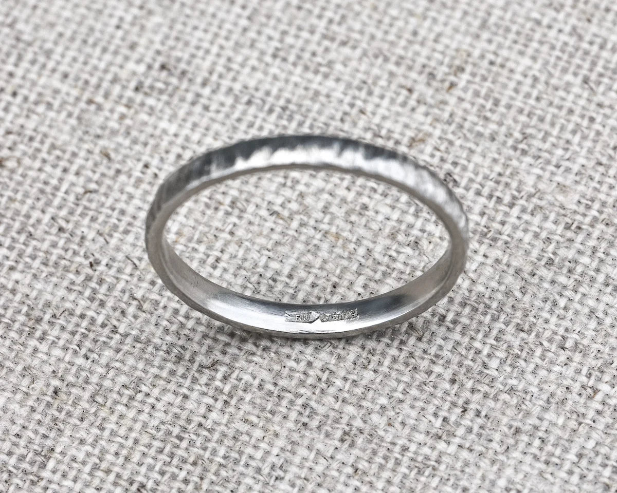 Silver ring on a textured fabric background