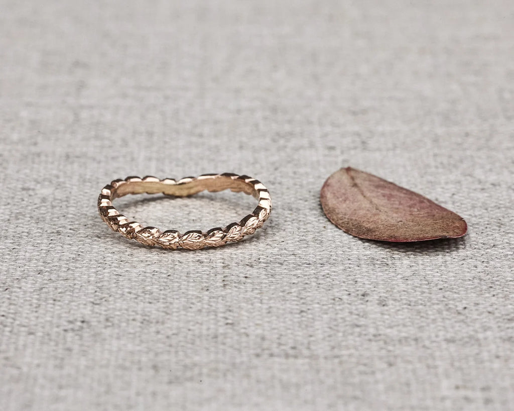 close up laurel leaf carving detail on 2mm rose gold wishbone ring