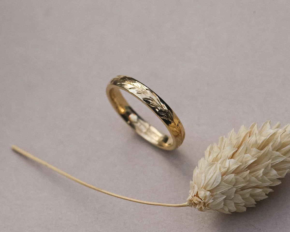 Detailed view of olive leaf engraving on 18ct yellow gold band