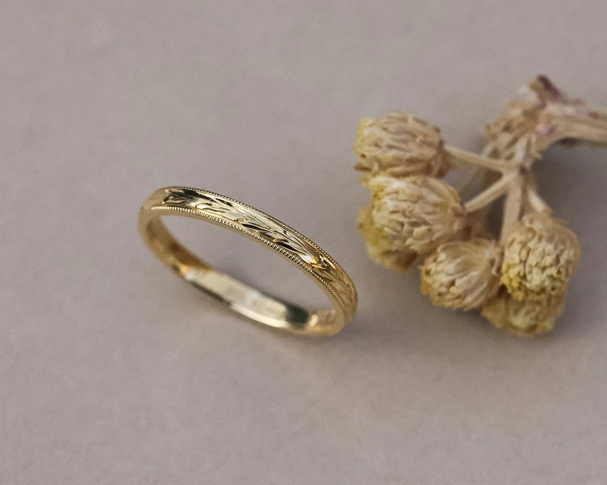 Detailed view of 18ct yellow gold flat court ring with milled edge