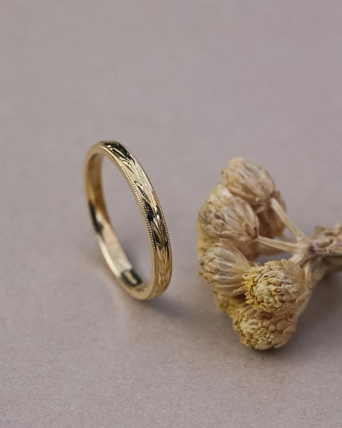 Vertical view of handmade olive leaf engraved ring in 18ct yellow gold