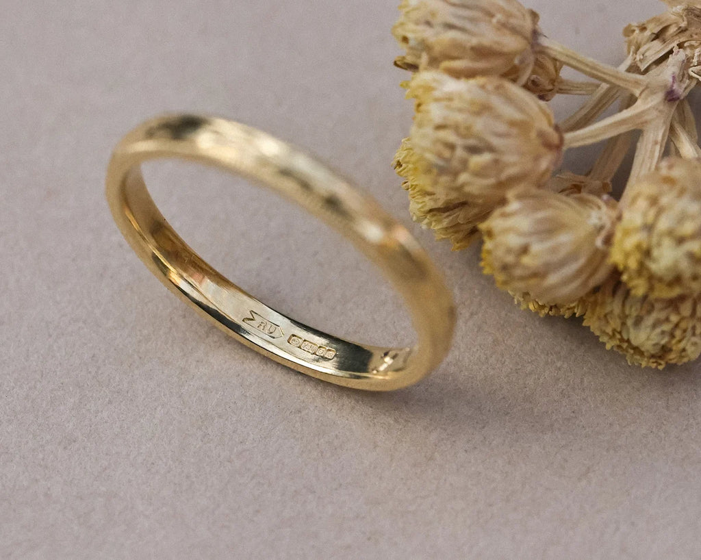 Close-up of hand engraved olive leaf detail on yellow gold band
