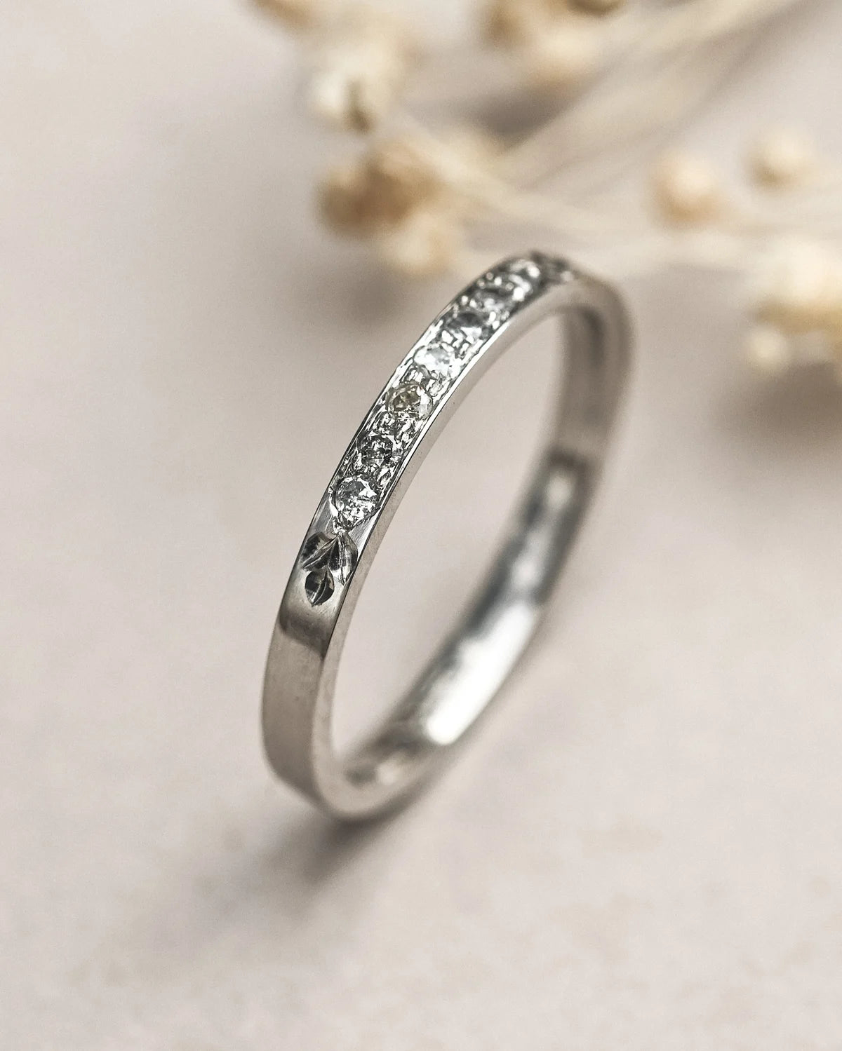 Silver ring with small diamonds on a light background