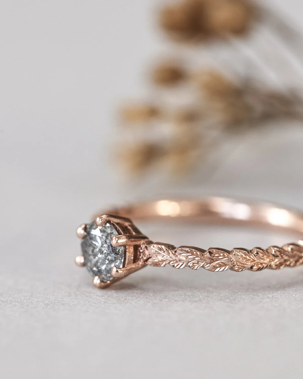 Rose gold ring with a diamond on a light background