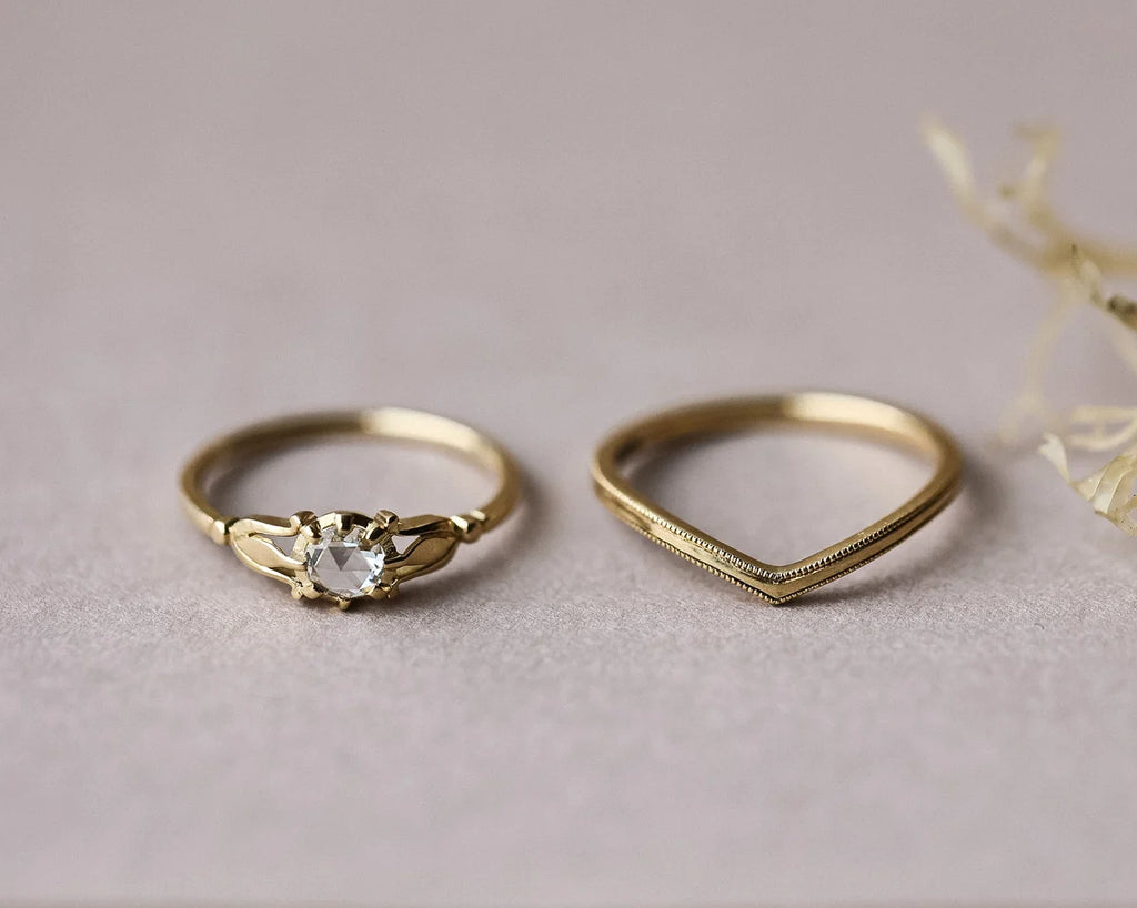 Two gold rings on a light gray surface