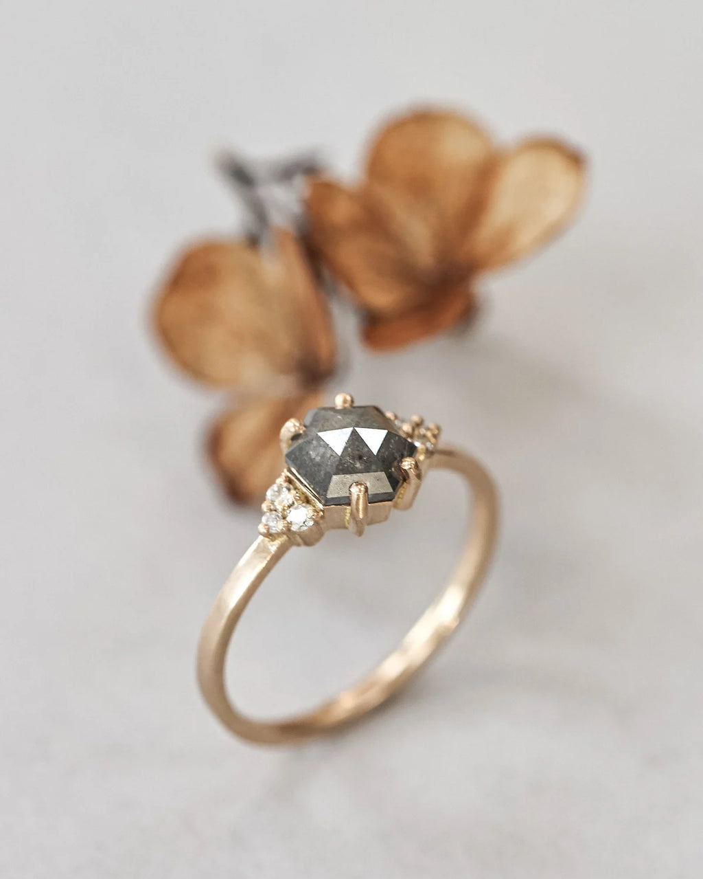 Side view of hexagonal rose-cut diamond ring with white diamond shoulders