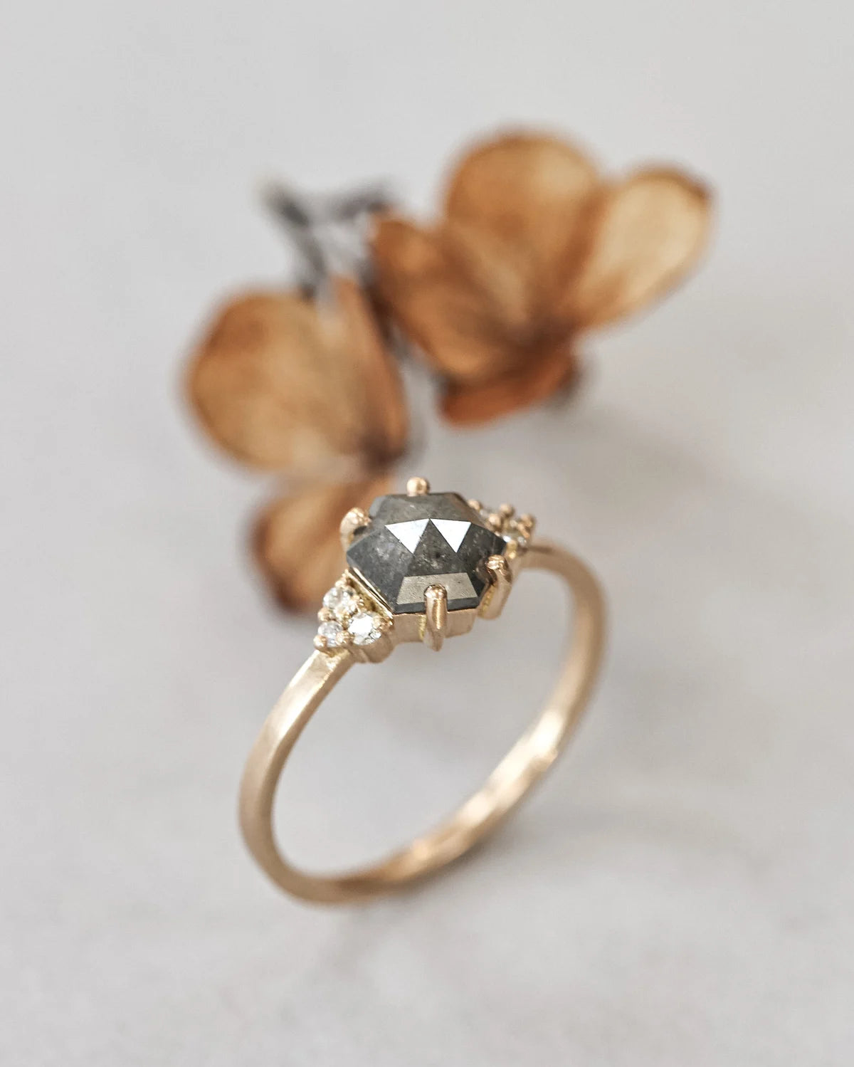 Side view of hexagonal rose-cut diamond ring with white diamond shoulders