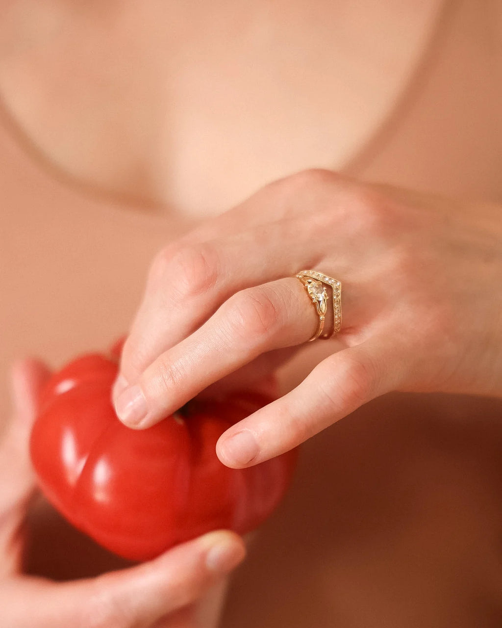 Editorial shot of a rose-cut diamond ring styled with a fresh tomato