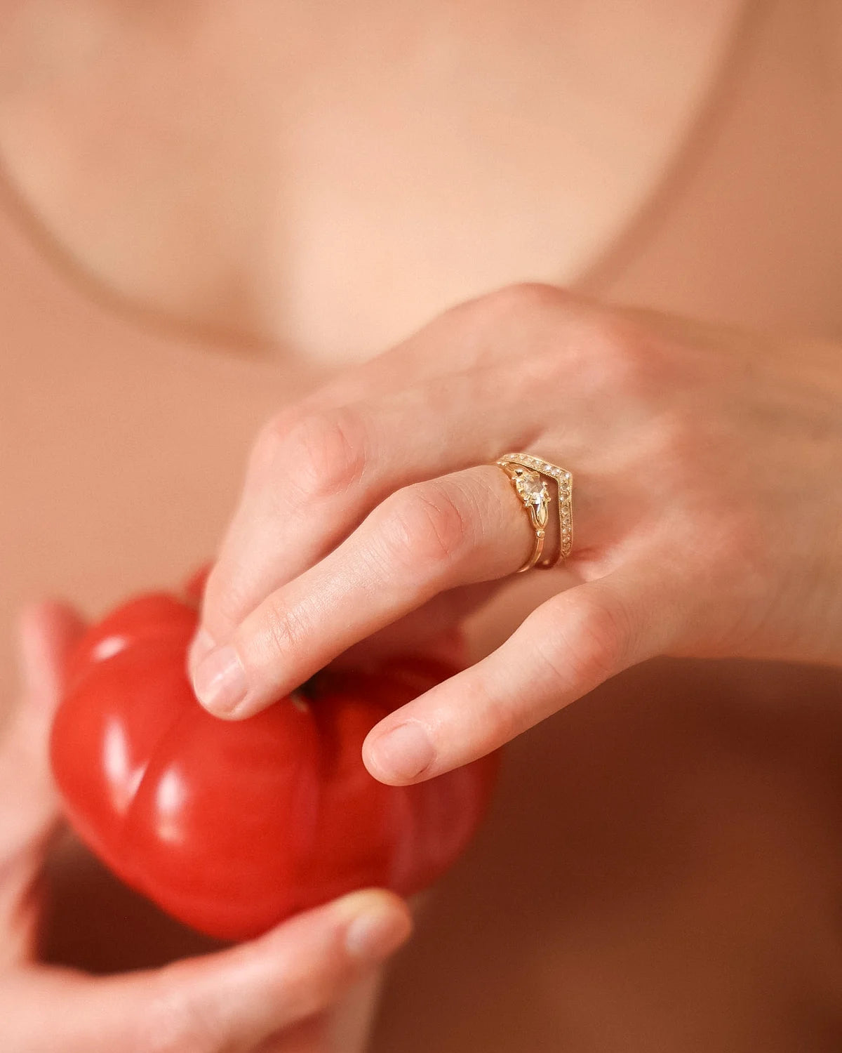 Editorial shot of a rose-cut diamond ring styled with a fresh tomato
