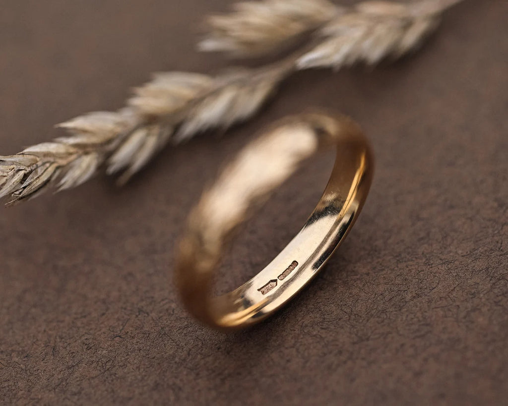Inside view of 9ct yellow gold court wedding ring with hallmark