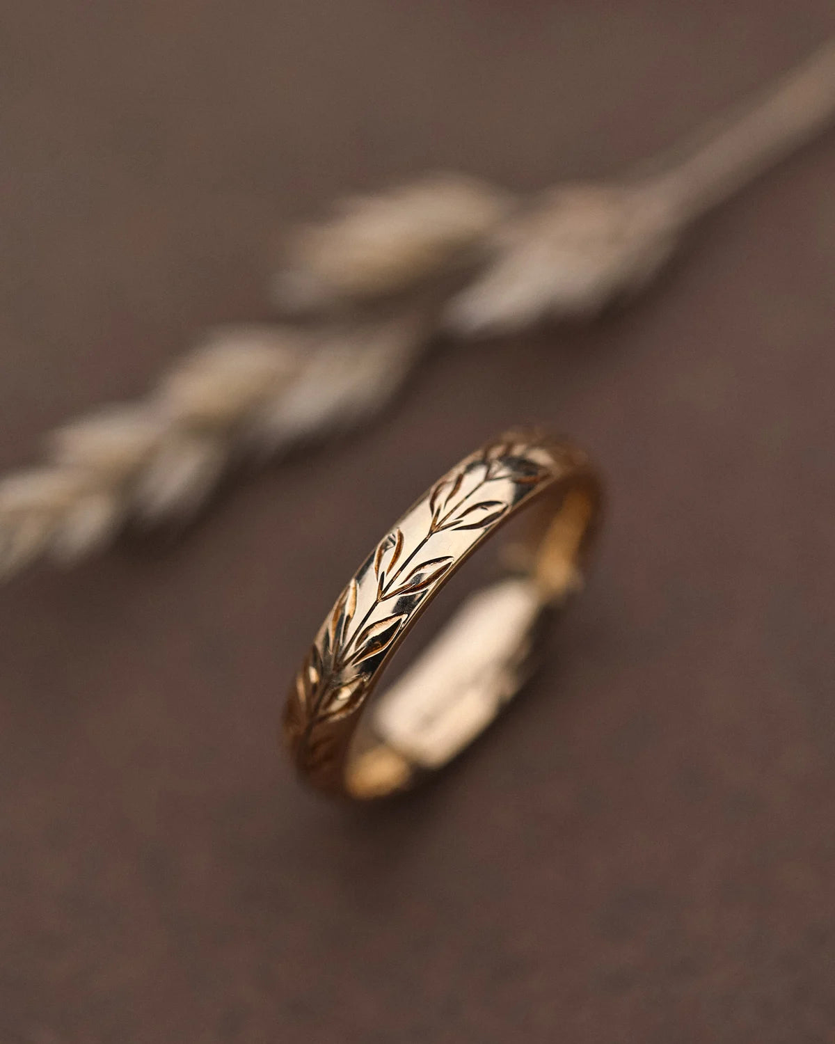 Side view of olive leaf engraved court wedding ring in yellow gold