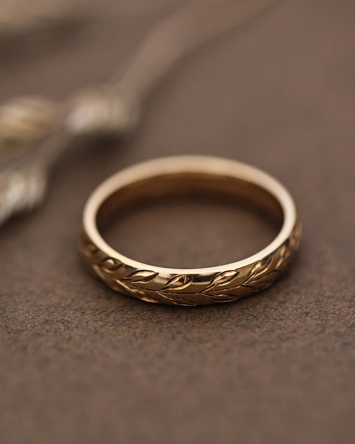 Front view of 4mm yellow gold wedding ring with olive leaf engraving