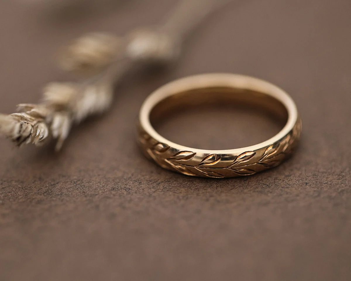 Low front view of olive leaf engraved yellow gold wedding band