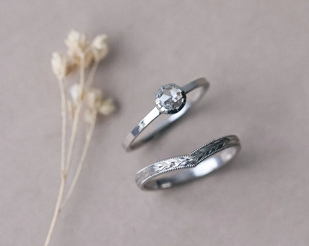Matching platinum wedding and engagement rings with botanical styling