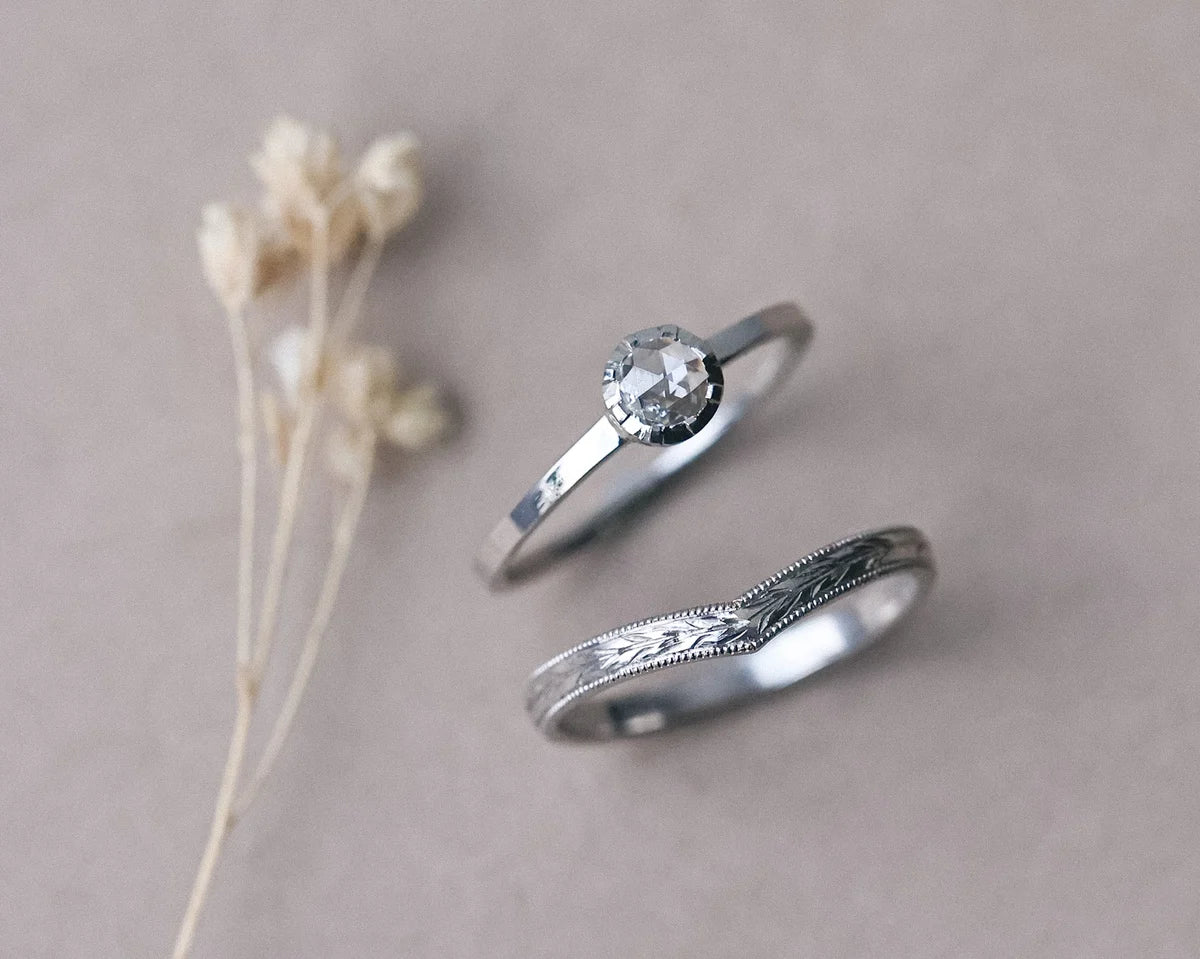 Matching platinum wedding and engagement rings with botanical styling