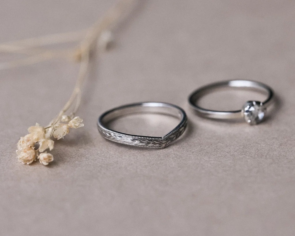 Platinum olive leaf wishbone ring shown beside rose-cut diamond ring